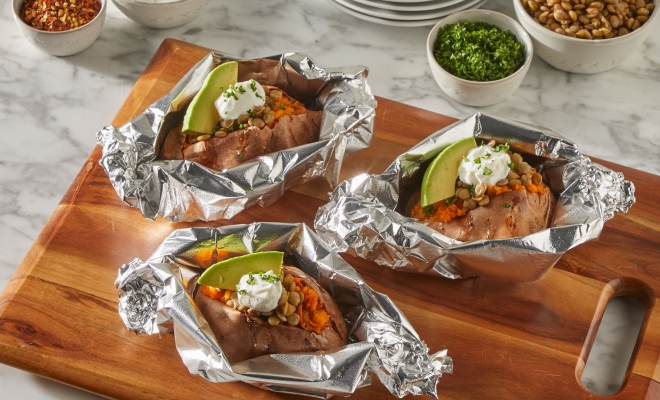 Sweet potatoes sitting in heavy duty aluminum foil packets