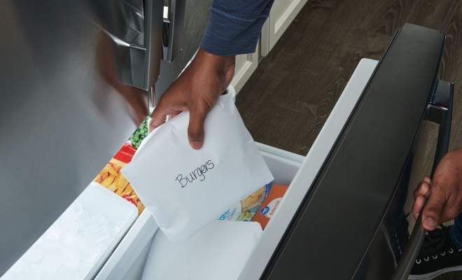 Man placing wrapped meat into freezer paper