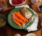 A plate with chicken and carrots wrapped in plastic paper