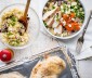 A quinoa bowl on a table and chicken