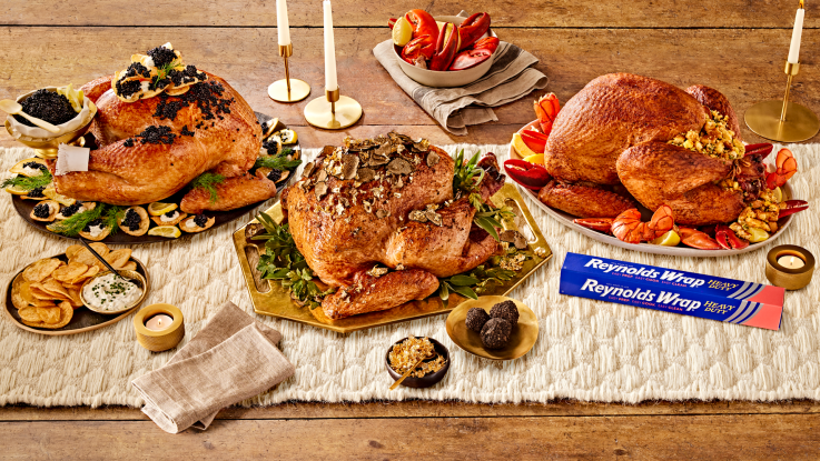 Trio of cooked turkeys alongside a box of Reynolds Wrap heavy duty foil